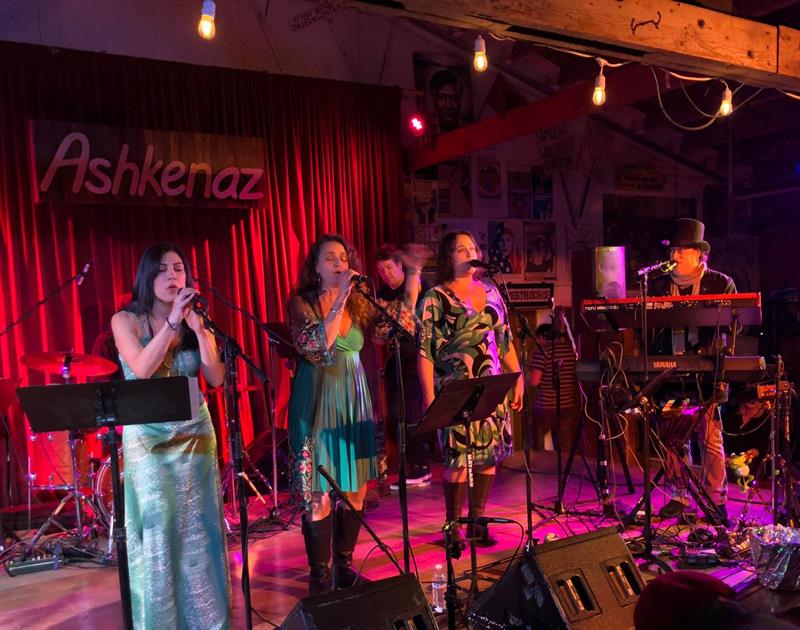 Enjoyus performing at Ashkenaz with bright red stage lighting